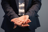 Businesswoman in suit holding her hands out