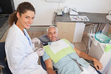 Patient and dentist smiling at camera