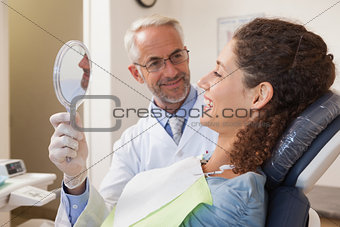 Patient admiring her new smile in the mirror
