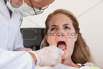 Dentist about to pull a terrified patients tooth