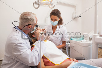 Dentist and assistant examining patients teeth