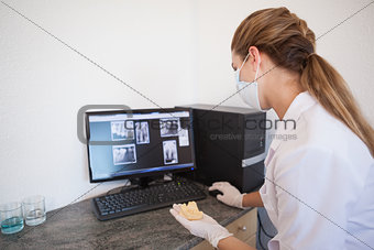 Dental assistant looking at x-rays on computer