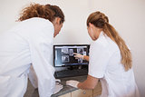 Dentist and assistant studying x-rays on computer