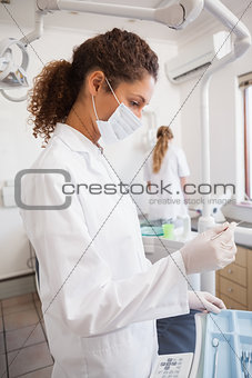 Dentist examining her tools on a tray