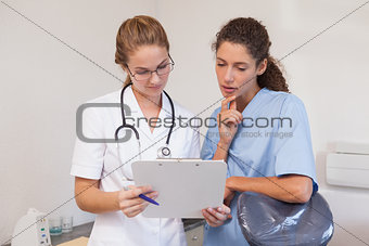 Dentist and dental assistant looking at clipboard