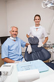 Dentist and assistant smiling at camera inviting you to the chair