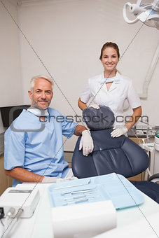 Dentist and assistant smiling at camera inviting you to the chair