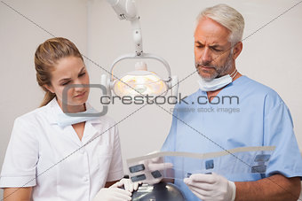 Dentist and assistant studying x-rays