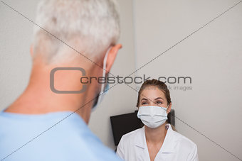 Dentist and assistant facing each other