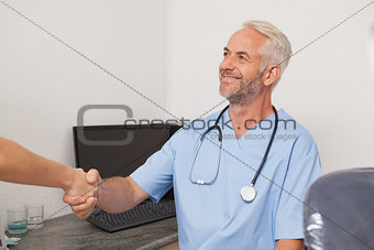 Dentist shaking hands with his patient