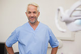 Dentist smiling at camera in blue scrubs