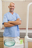 Dentist smiling at camera in blue scrubs