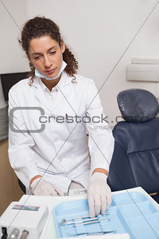 Dentist picking up a tool beside the chair