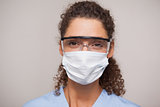 Dentist in surgical mask and protective glasses looking at camera