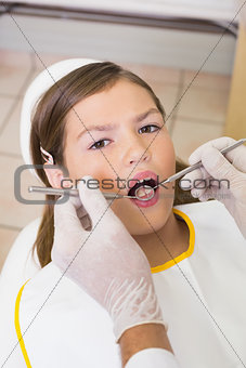 Pediatric dentist examining a patients teeth in the dentists chair