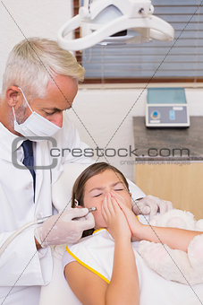 Pediatric dentist trying to see sneezing patients teeth