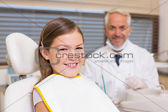 Pediatric dentist and little girl smiling at camera