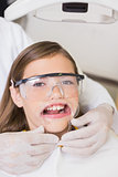 Dentist putting mouth retractor on little girl