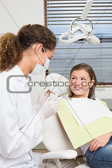 Pediatric dentist speaking with little girl in the dentists chair