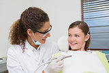 Pediatric dentist smiling with little girl in the chair