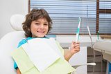 Little boy in dentists chair holding toothrbrush