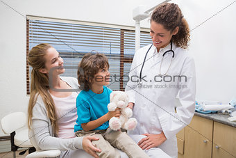 Pediatric dentist smiling at little boy with his mother