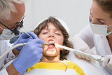 Pediatric dentist and assistant examining a little boys teeth