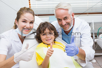 Pediatric dentist assistant and little boy all smiling at camera with thumbs up