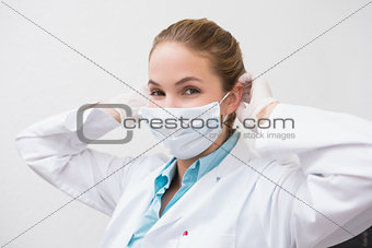 Dentist putting on her surgical mask