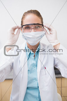 Dentist putting on her protective glasses