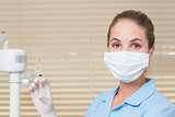 Dental assistant holding injection looking at camera