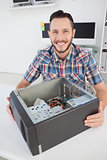 Computer engineer smiling at camera beside open console