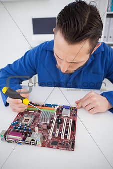 Computer engineer working on cpu with screwdriver