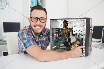 Computer engineer working on broken console smiling at camera