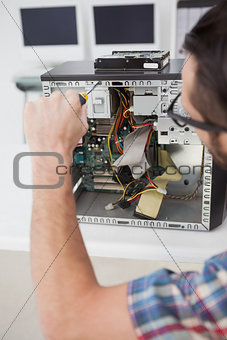 Computer engineer working on broken console with screwdriver
