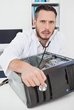 Computer engineer listening to console with stethoscope