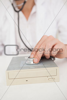 Computer engineer listening to harddrive with stethoscope