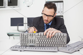 Technician fixing keyboard with screw driver