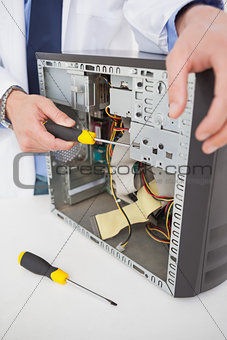 Computer engineer working on broken console with screwdriver