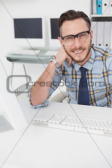 Happy casual businessman working at his desk