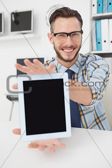 Happy casual businessman showing tablet pc