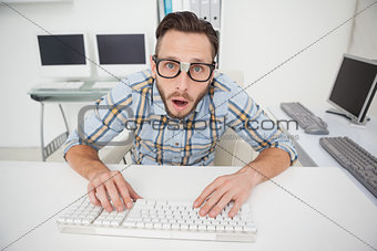 Puzzled nerdy businessman working on computer