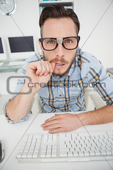 Puzzled nerdy businessman working on computer