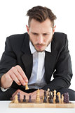 Focused businessman playing chess solo
