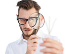 Nerdy businessman looking through magnifying glass