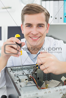 Computer engineer working on broken device with screwdriver