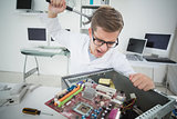 Computer engineer holding hammer over broken console