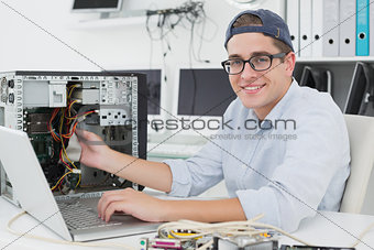 Computer engineer working on broken console with laptop