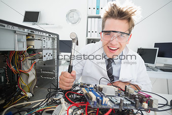 Crazed computer engineer holding hammer over console