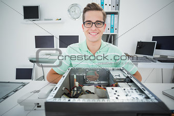 Smiling technician working on broken computer